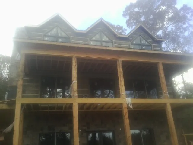Dormers and porch framing on a large log home under construction — Roof Coating work by our crew in Kimmell