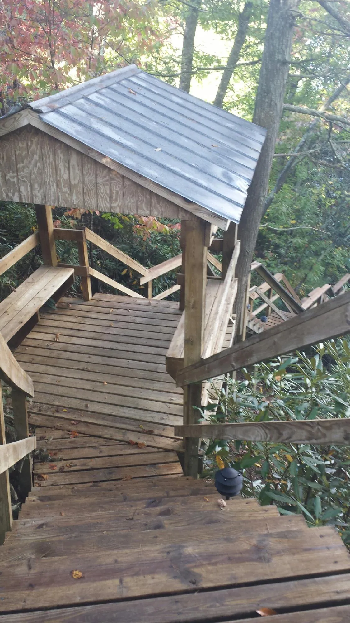 Metal roofed shelter over wooden steps on a wooded walkway — Skylight Repair & Installation work by our crew in Kimmell