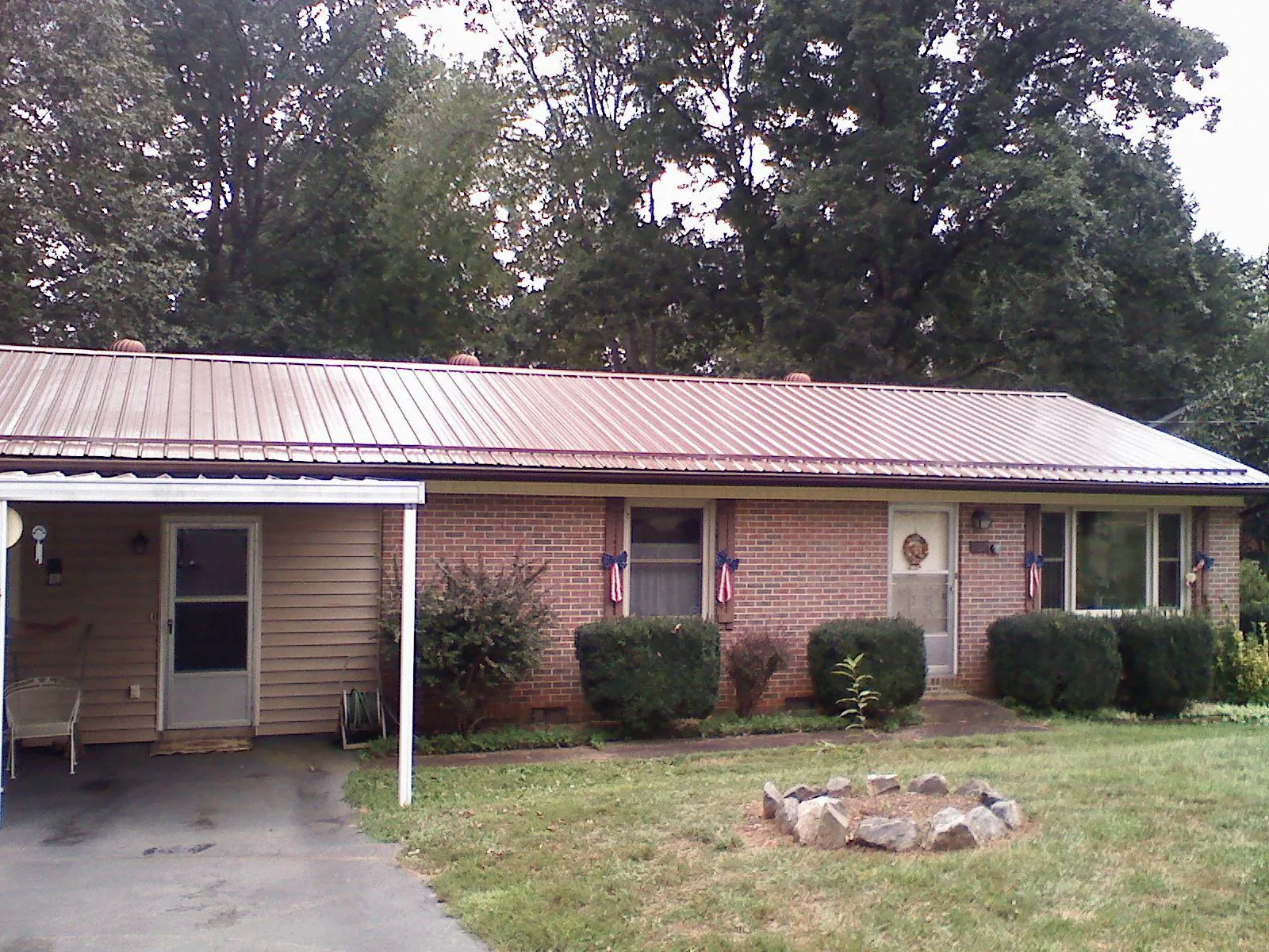 Bronze metal roof and carport on a brick ranch home — Roof Repair work by our crew in Kimmell